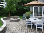 Patio showing table and seating wall with fire pit